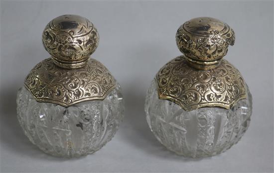 A pair of Edwardian silver mounted cut glass globular scent bottles (1 af), J.H Worrall Son & Co, Birmingham, 1901 & 7, 11.2cm.